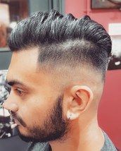 Skin fade, swept back A low bald fade into disconnected top, swept back with volume.